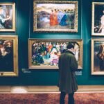 Man Standing in Front of Paintings